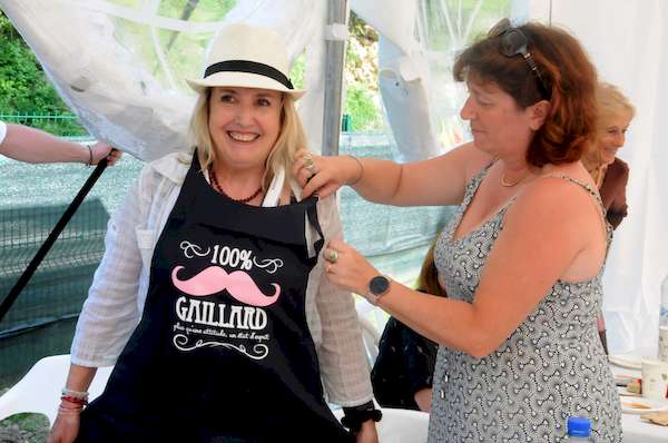 Photo de Muriel passant un tablier portant l'inscription 100% Gaillard